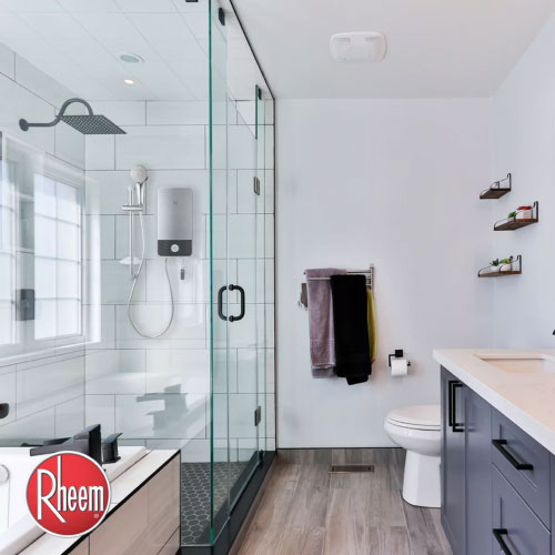 An electric shower heater seen inside minimalist bathroom with glass door 